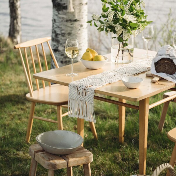 Aurinko-kaitaliina koristaa kesäistä kattausta järven rannalla.