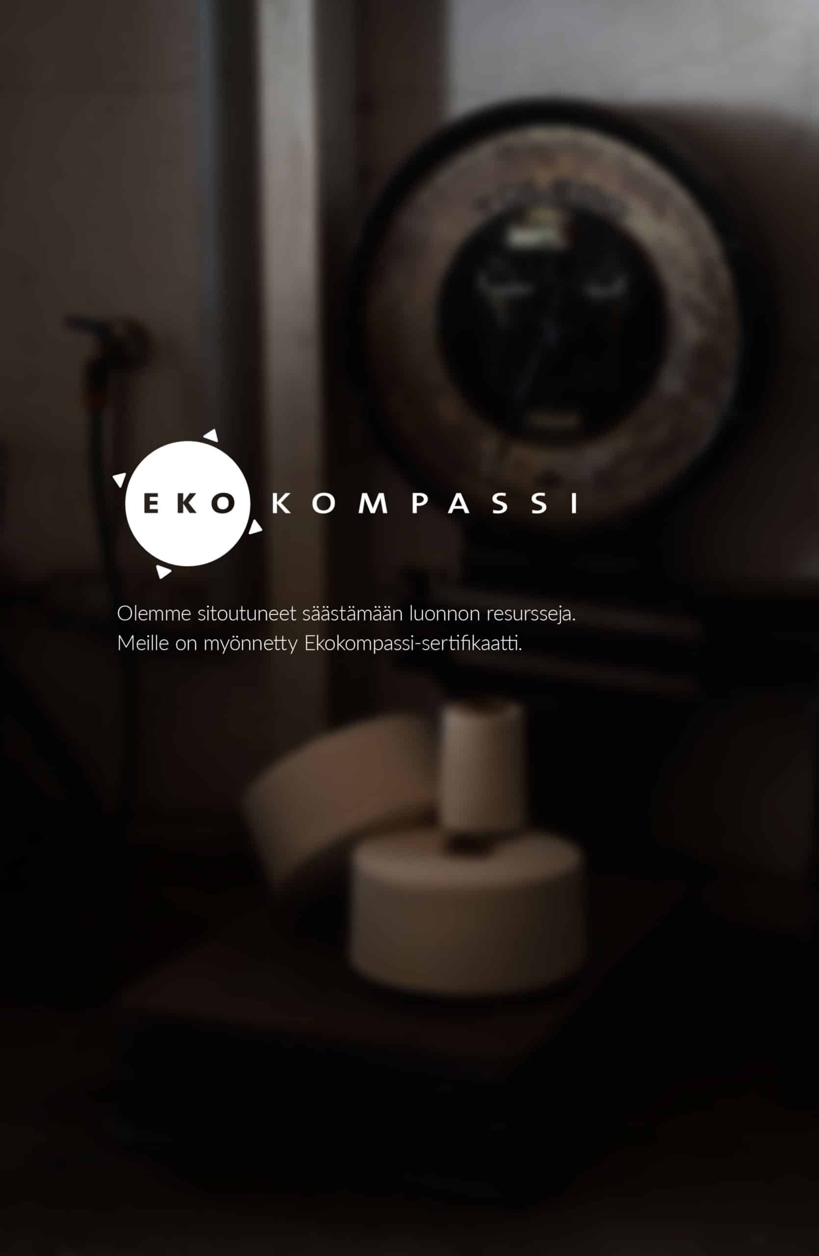 Vastuullisuus: Ekokompassi-sertifikaatti ja vanha metallivaaka hämärässä työpajaympäristössä.